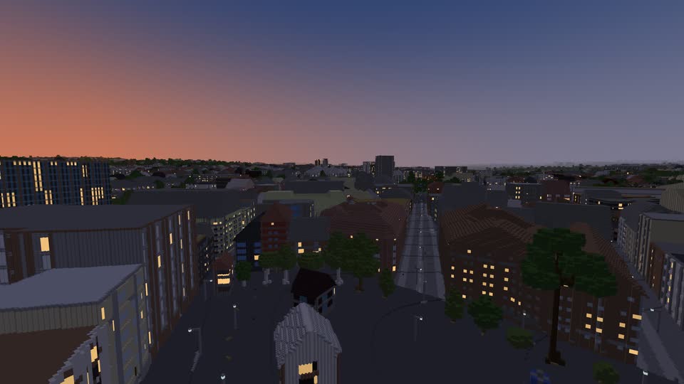 The city at dusk with an orange sky and lit windows